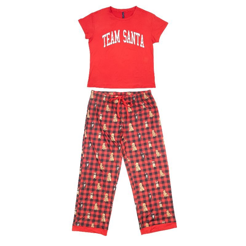 A two-piece kids' pajama set featuring a red short-sleeve t-shirt with 'TEAM SANTA' printed in white arched letters, and matching red and black buffalo plaid pants decorated with small Santa Claus silhouettes, shown on a plain white background.