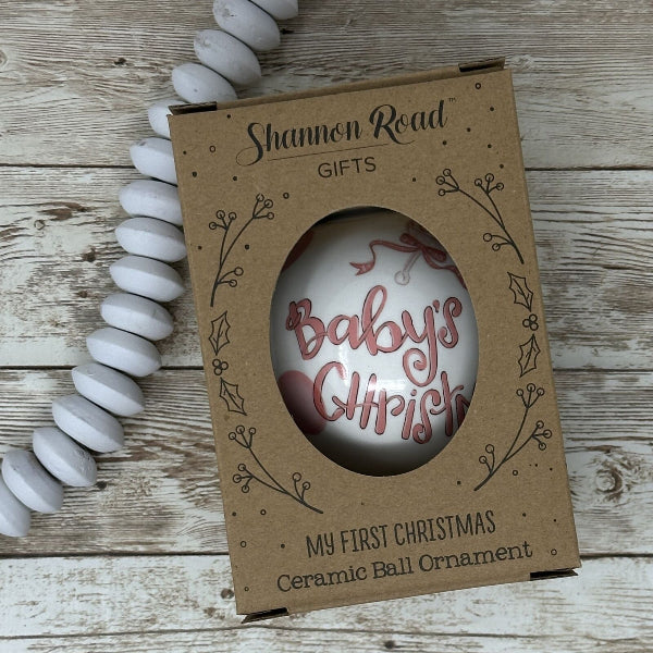Ceramic ball ornament in a cardboard box on a wooden surface.