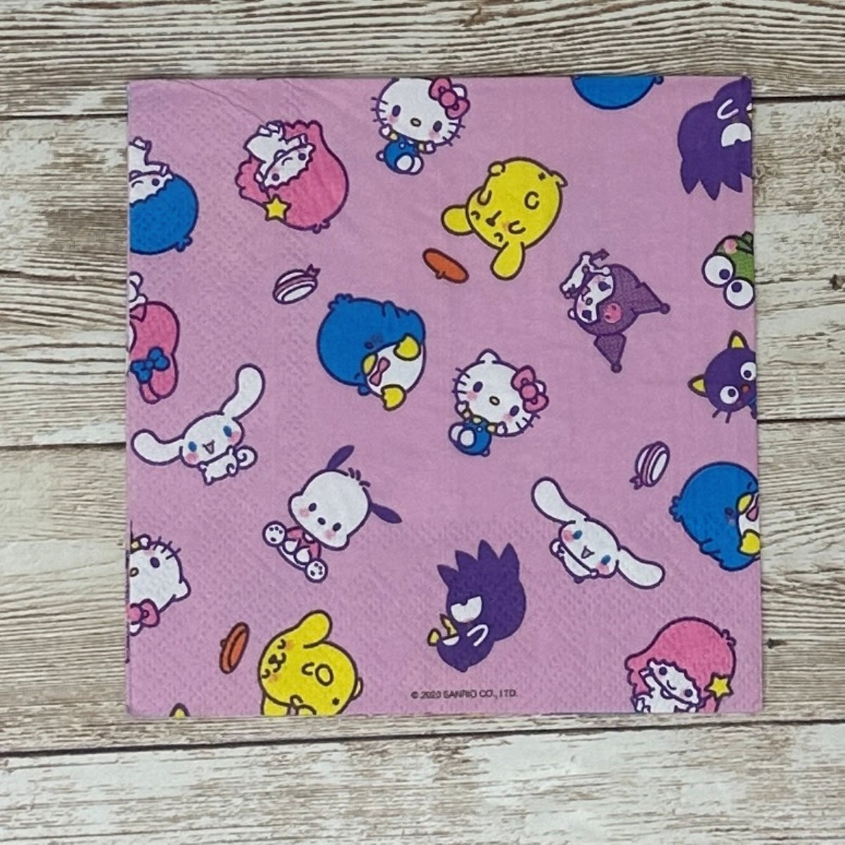 Cocktail size decoupage paper napkin featuring the Sanrio character family including Hello Kitty Cinnamoroll My Melody Pompompurin and Badtz-Maru scattered across a sweet lavender pink background set of 2