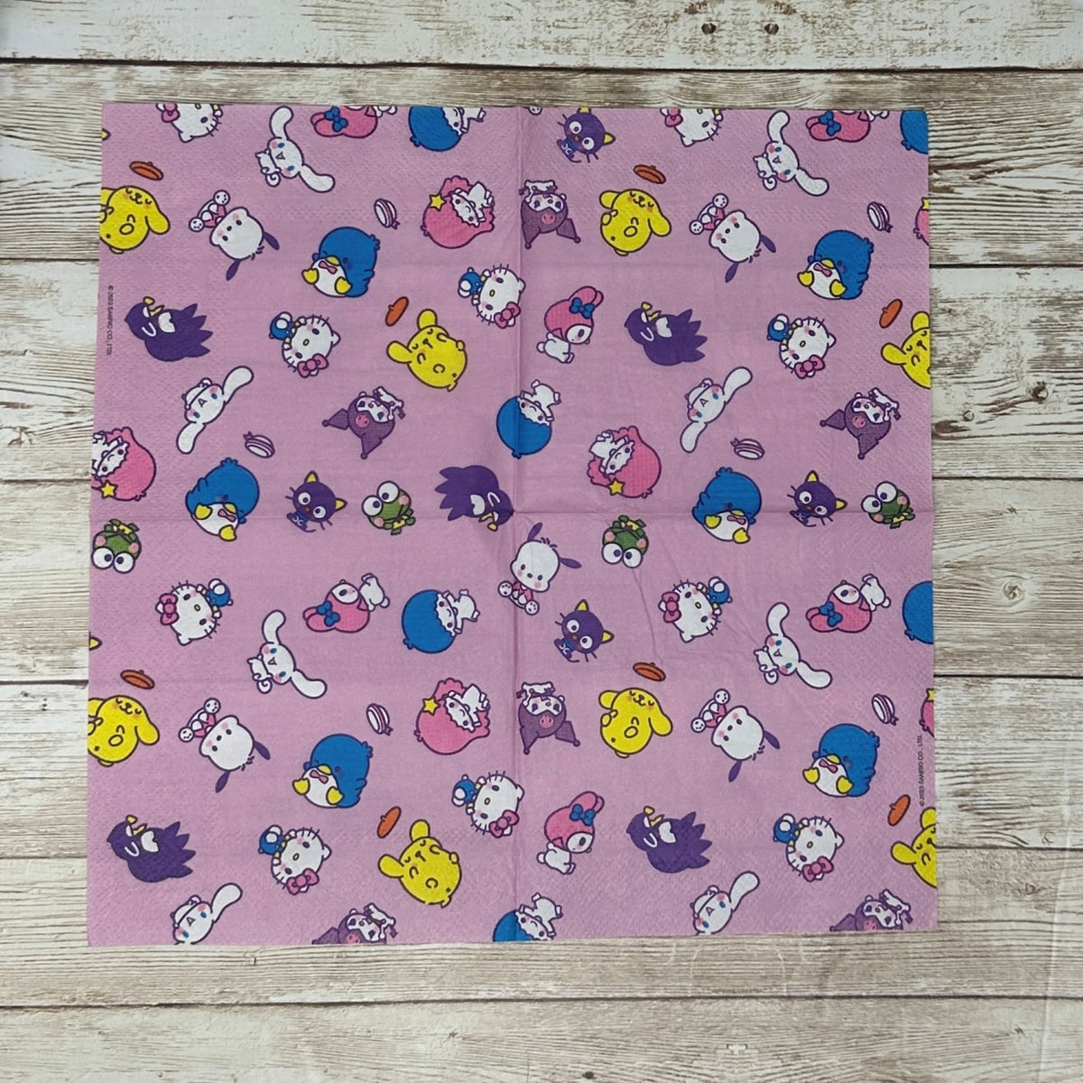 Cocktail size decoupage paper napkin featuring the Sanrio character family including Hello Kitty Cinnamoroll My Melody Pompompurin and Badtz-Maru scattered across a sweet lavender pink background set of 2