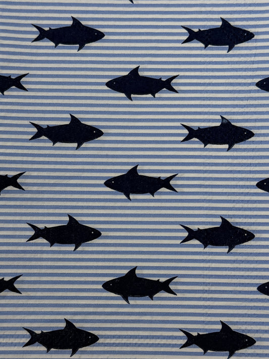 Two guest size decoupage napkins featuring bold navy blue shark silhouettes scattered across a light blue and white pinstripe background set of 2
