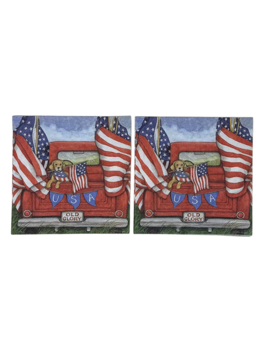 Luncheon size decoupage paper napkin featuring a golden retriever in a flag bandana peeking over the tailgate of a classic red pickup truck flying large American flags with a USA bunting banner and Old Glory license plate set of 2