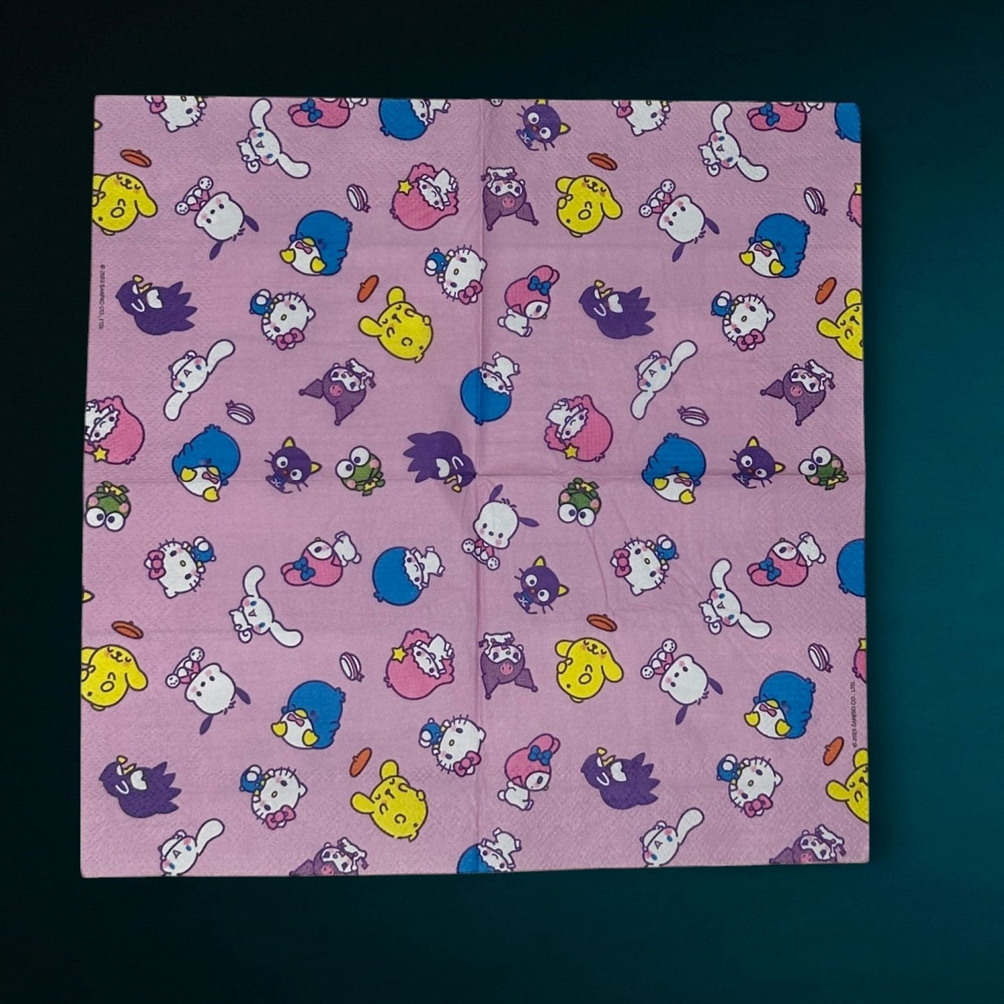 Cocktail size decoupage paper napkin featuring the Sanrio character family including Hello Kitty Cinnamoroll My Melody Pompompurin and Badtz-Maru scattered across a sweet lavender pink background set of 2