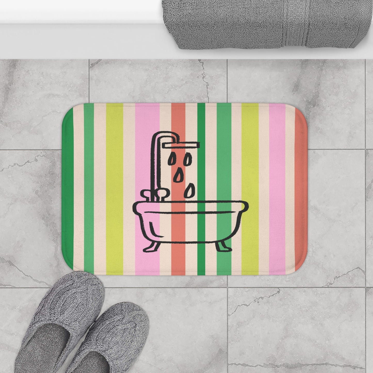 Striped bath mat with bathtub and shower design on a tiled bathroom floor.