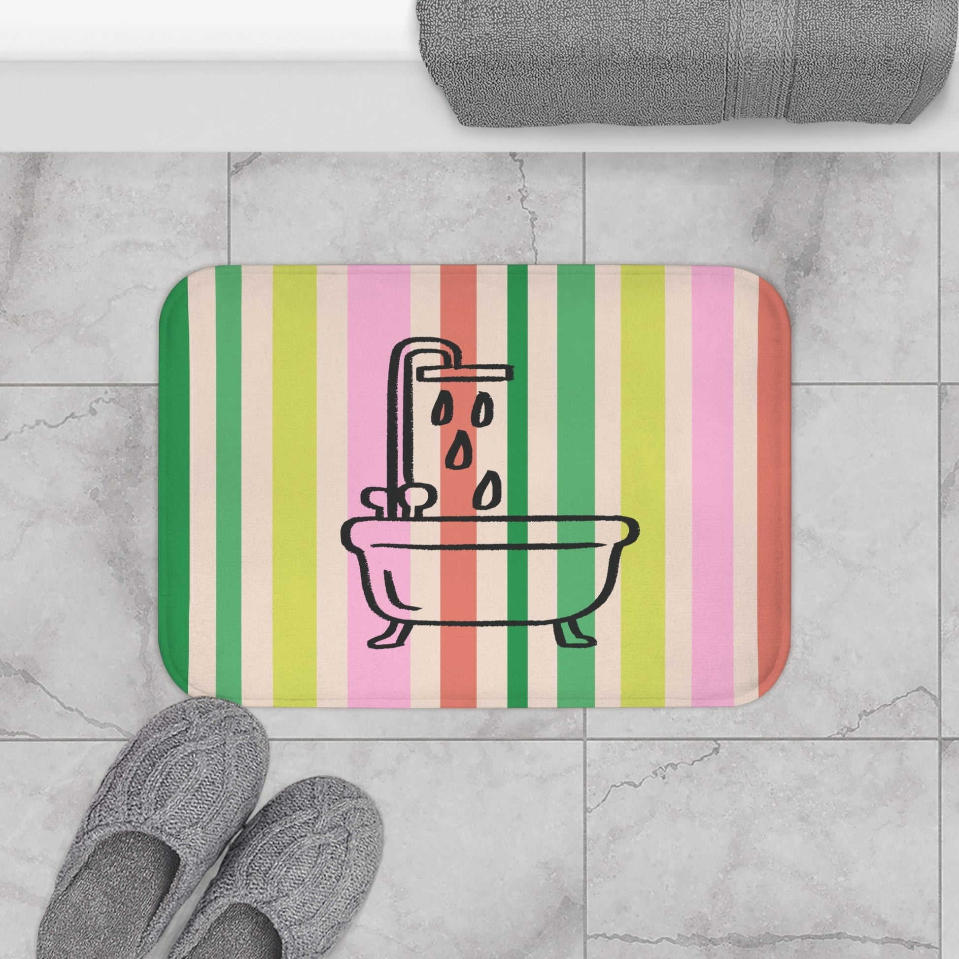 Striped bath mat with bathtub and shower design on a tiled bathroom floor.