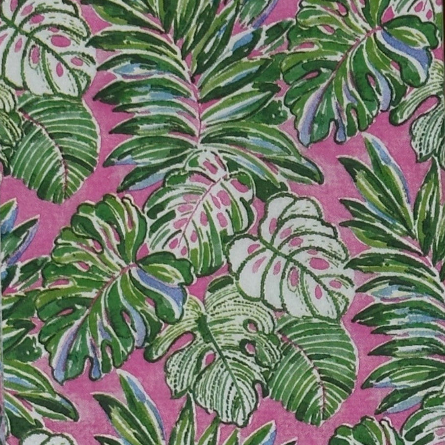 pink background with green palm fronds on a paper napkin