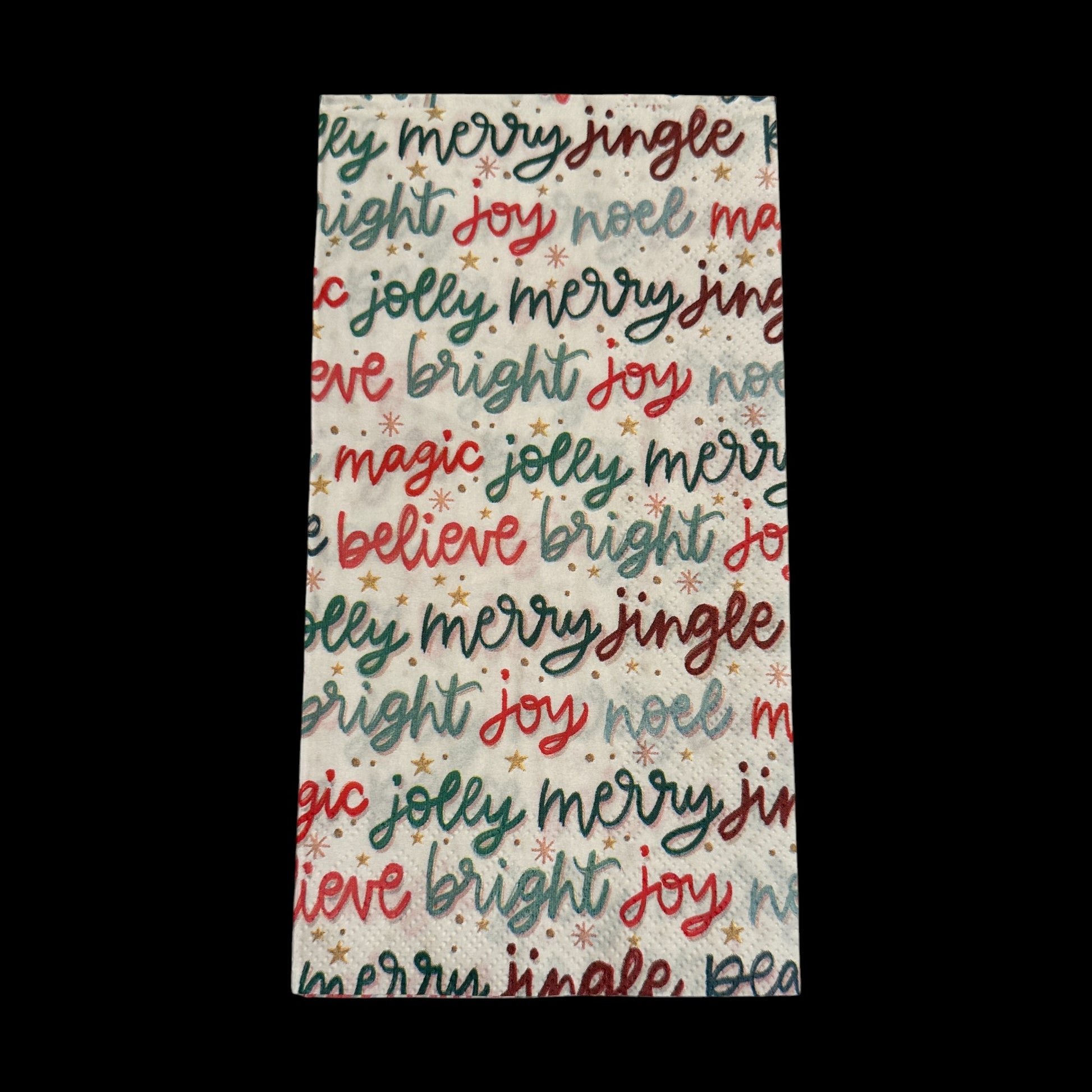 Guest size decoupage napkin featuring colorful Christmas word art with phrases like joy, merry, bright, jingle, and believe in red, green, and gold.