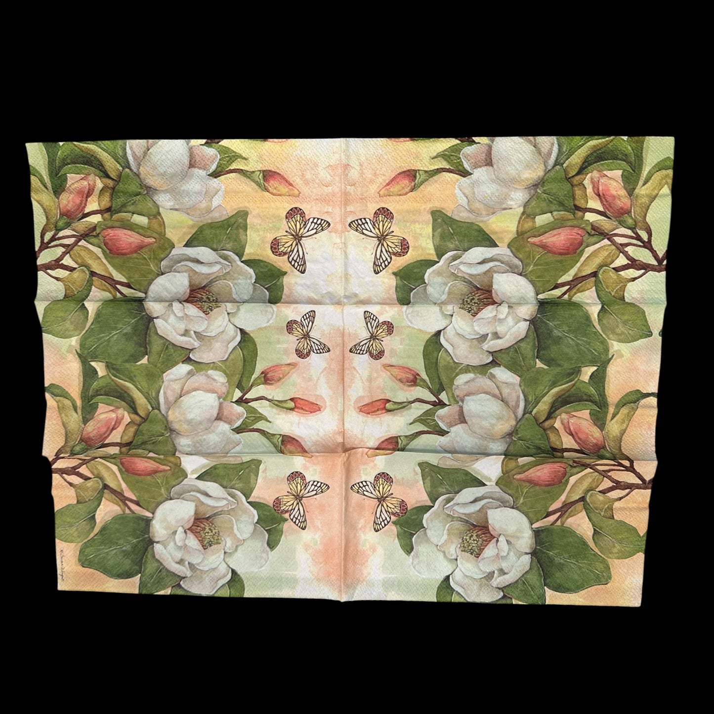 Unfolded Guest size decoupage napkin featuring white magnolia flowers, green leaves, and a butterfly on a soft background, ideal for floral crafts and spring decor.