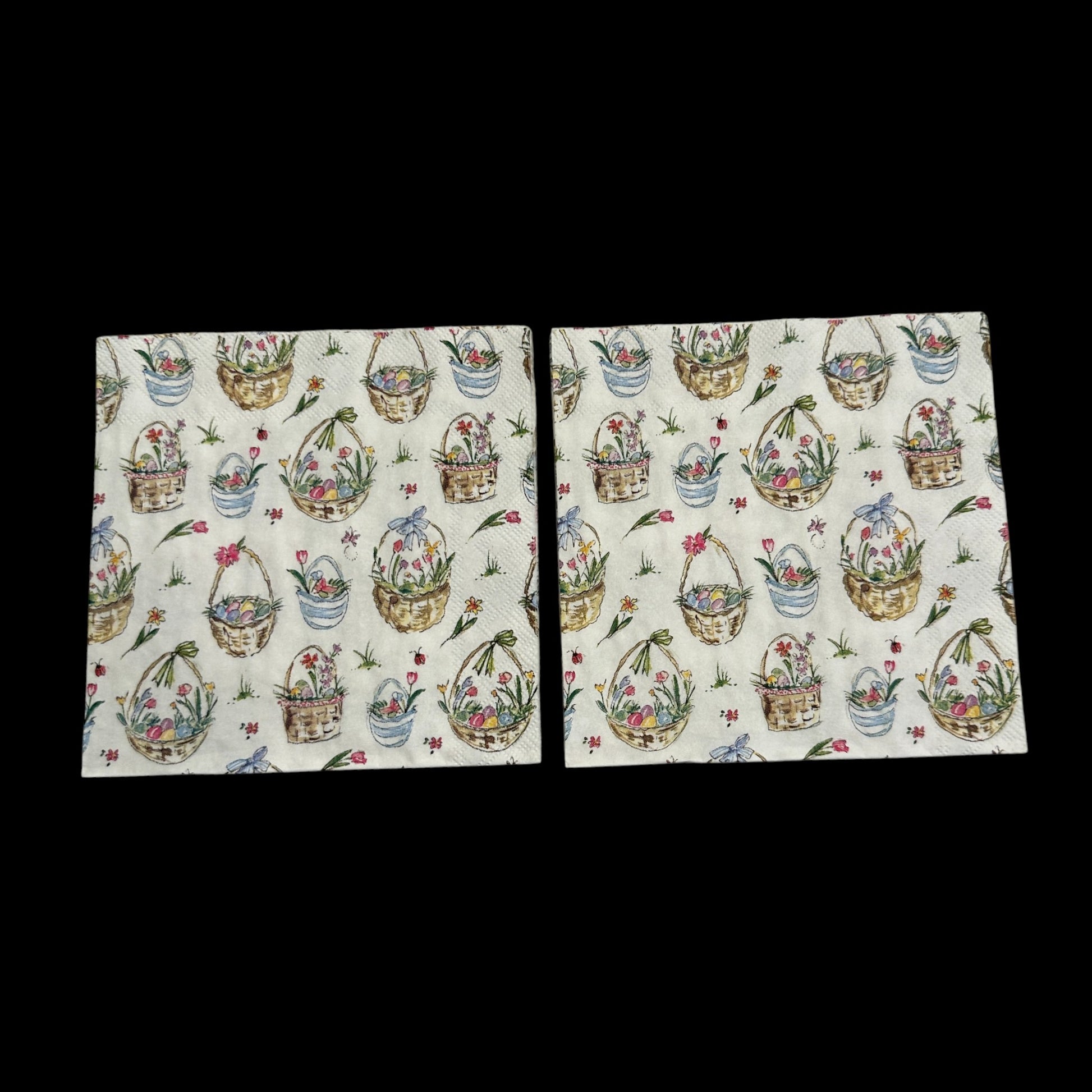 Two Cocktail size decoupage napkin featuring Easter baskets filled with flowers, eggs, and ribbons on a white background for spring and Easter crafts.