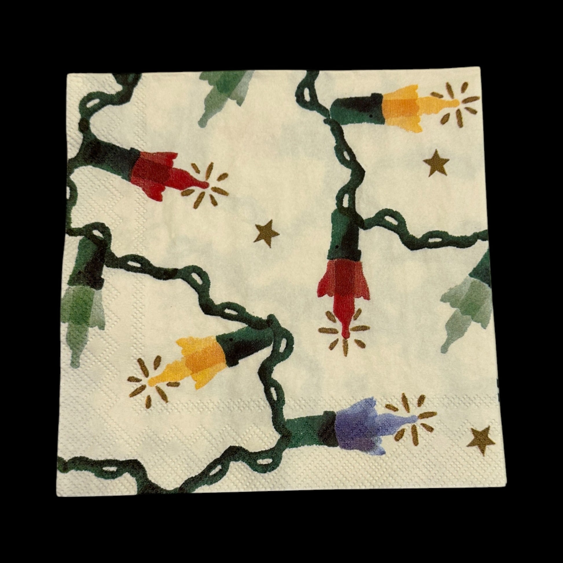 Christmas string light decoupage napkin featuring colorful red, yellow, green, and blue bulbs with glowing accents and small gold stars on a cream background.