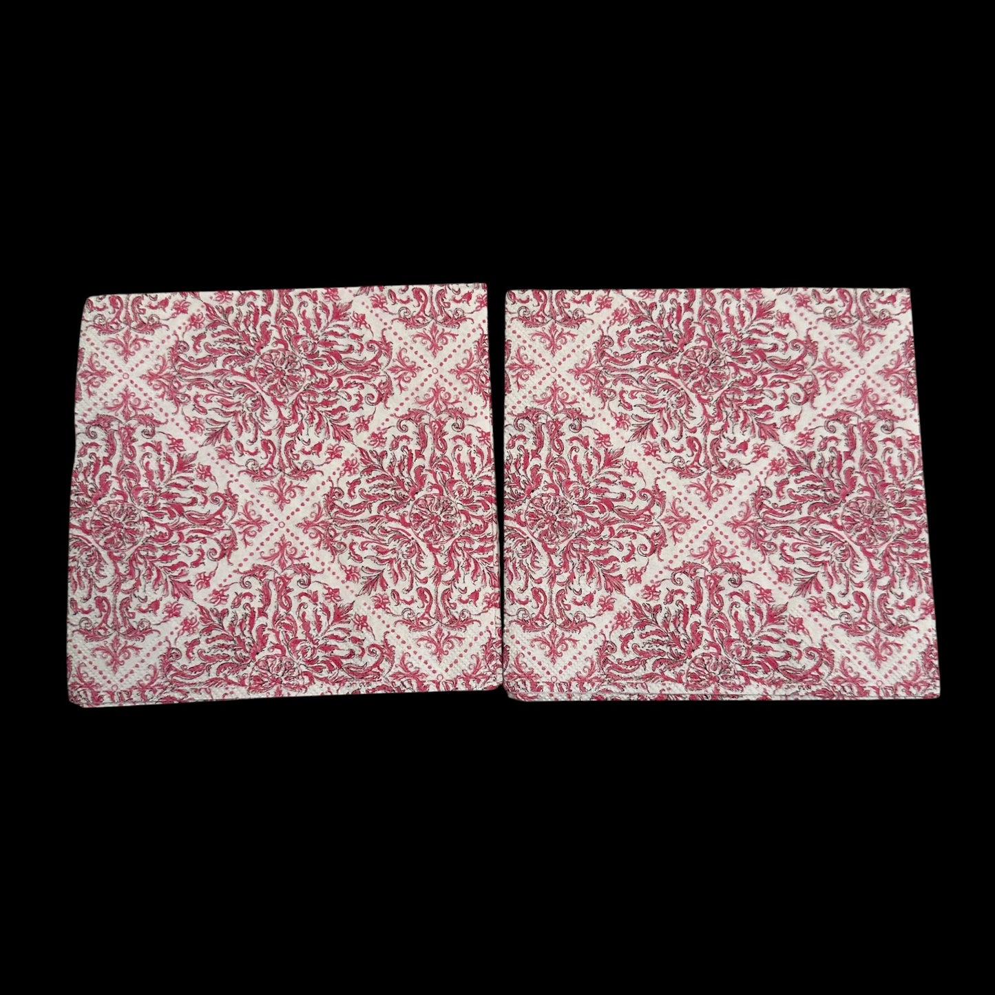 Two pink and white damask-style decoupage napkin with an ornate floral scroll pattern arranged in a repeating diamond design on a cream background.