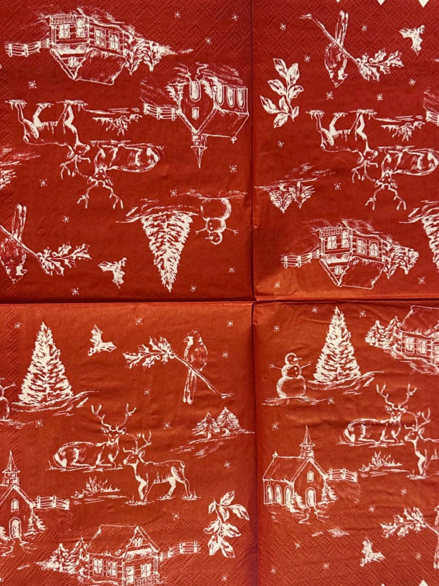 Cocktail size decoupage napkin with scalloped white edge featuring a classic red and white Christmas winter toile scene with snowman deer church cabin cardinal and holly sprigs set of 2