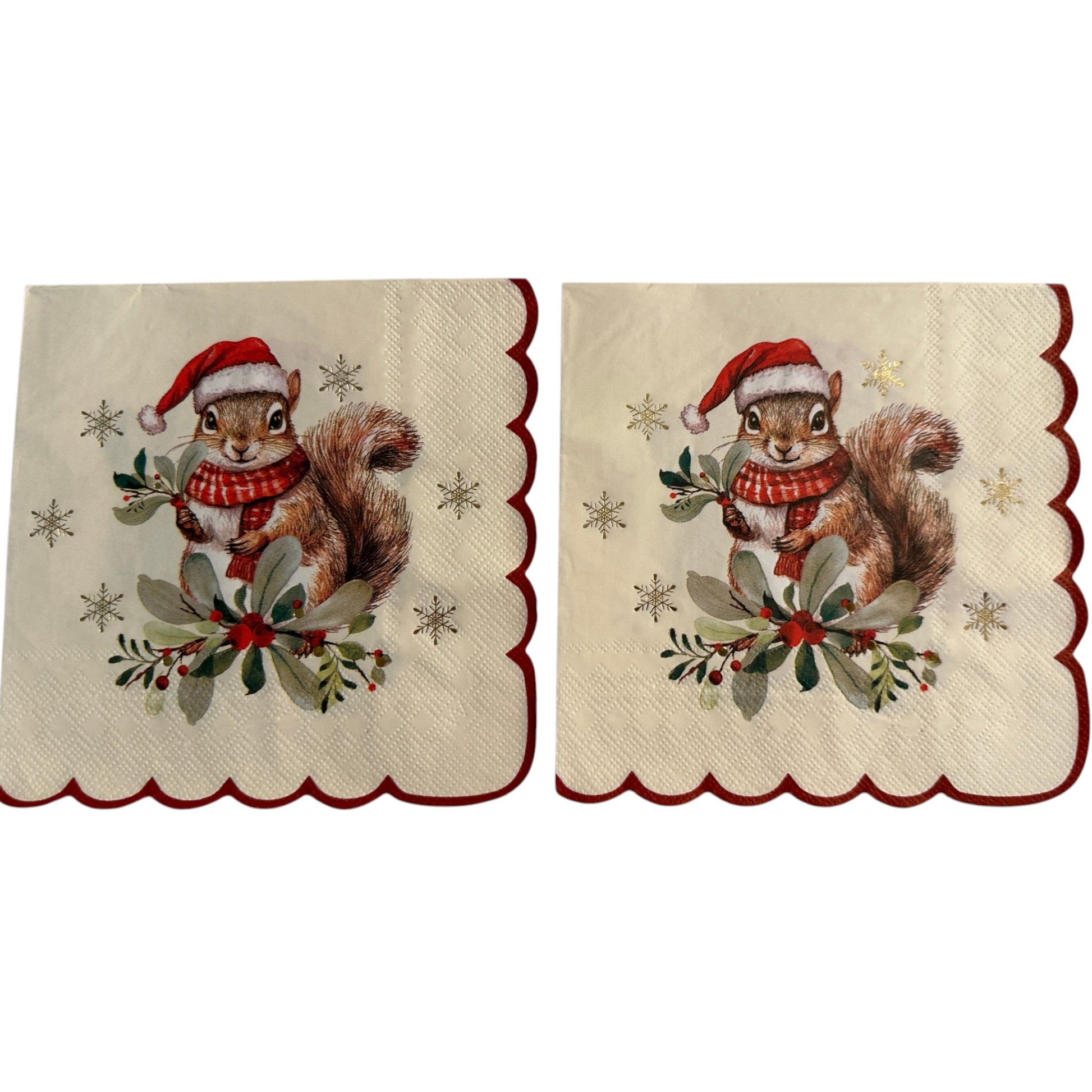 Two Christmas-themed paper napkins with scalloped edges, featuring a brown squirrel wearing a red Santa hat and scarf, surrounded by green leaves, red berries, and gold stars on a cream background.