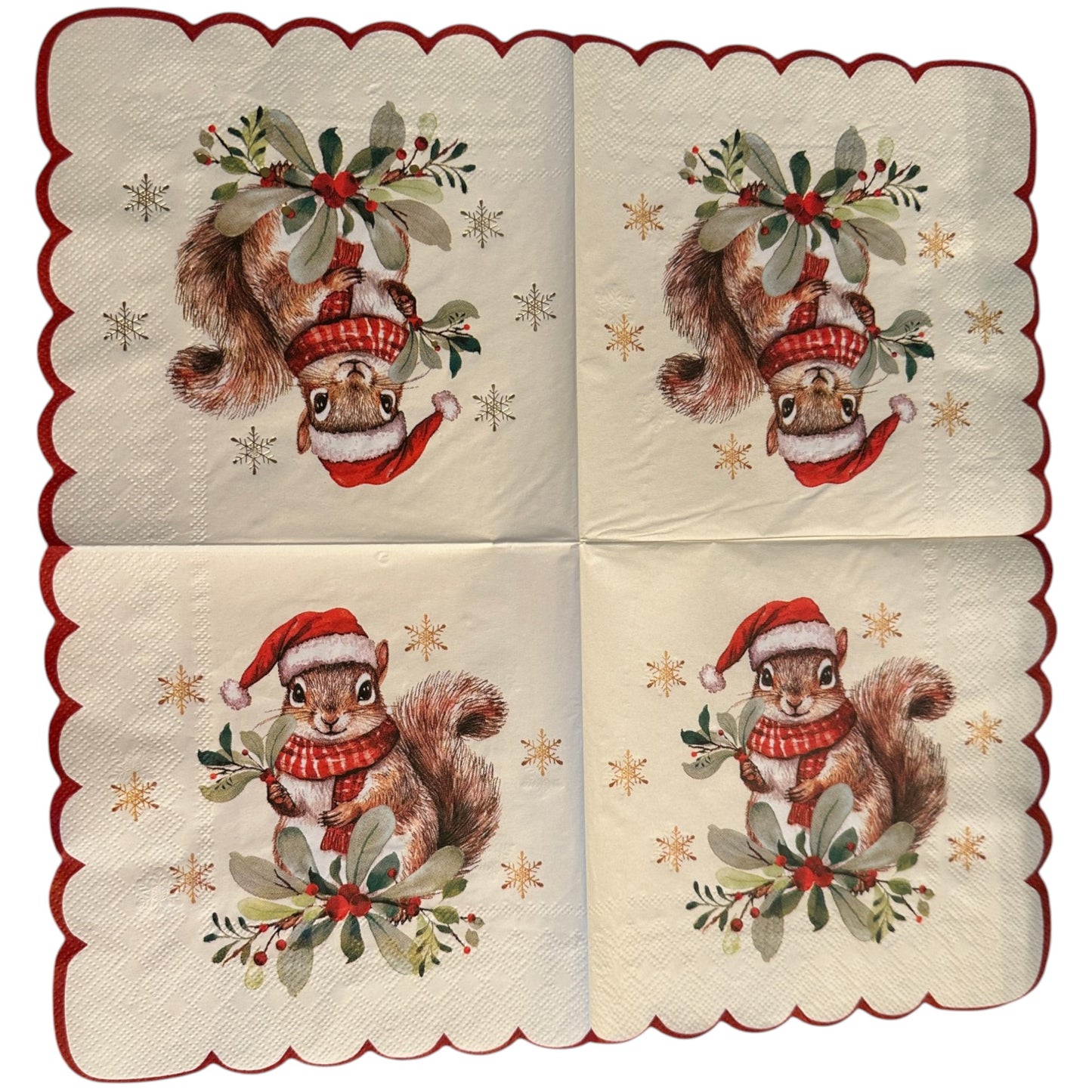 A set of four square paper napkins with scalloped edges, featuring a vintage-style illustration of a squirrel wearing a red Santa hat and scarf, surrounded by green holly leaves and gold stars, with a red border.