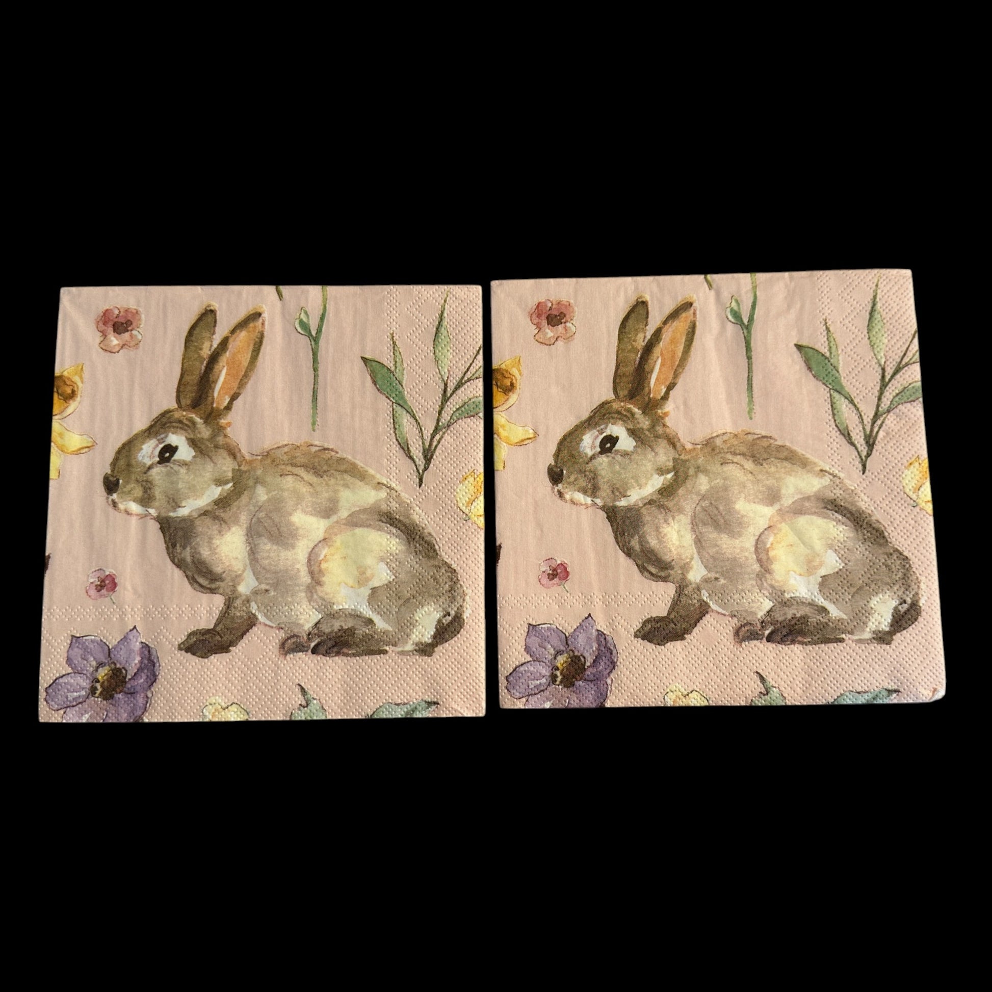 Luncheon size decoupage napkin featuring a watercolor garden bunny surrounded by wildflowers in blush pink lavender and butter yellow on a soft pink background set of 2
