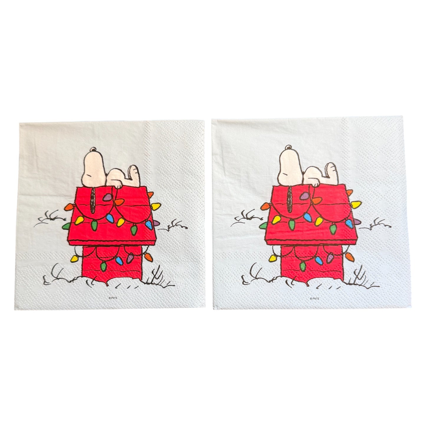 Cocktail size decoupage napkin featuring Snoopy lounging on his red dog house wrapped in colorful multicolored Christmas lights on a white winter background set of 2