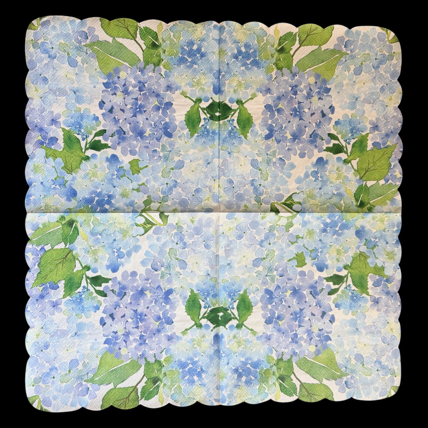 Unfolded luncheon size decoupage paper napkin with scalloped edges featuring lush watercolor hydrangea clusters in periwinkle blue cornflower and violet with rich green leaves on a creamy white background 