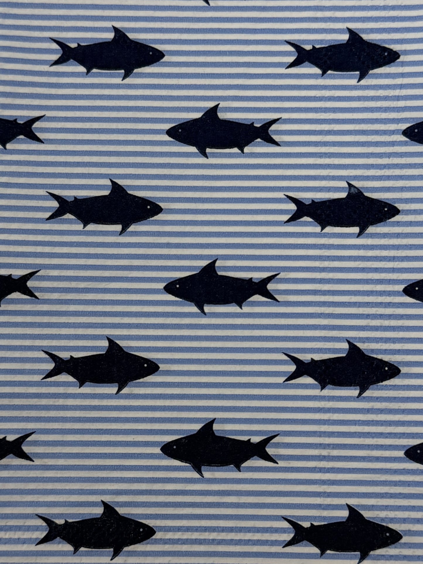 Two guest size decoupage napkins featuring bold navy blue shark silhouettes scattered across a light blue and white pinstripe background set of 2