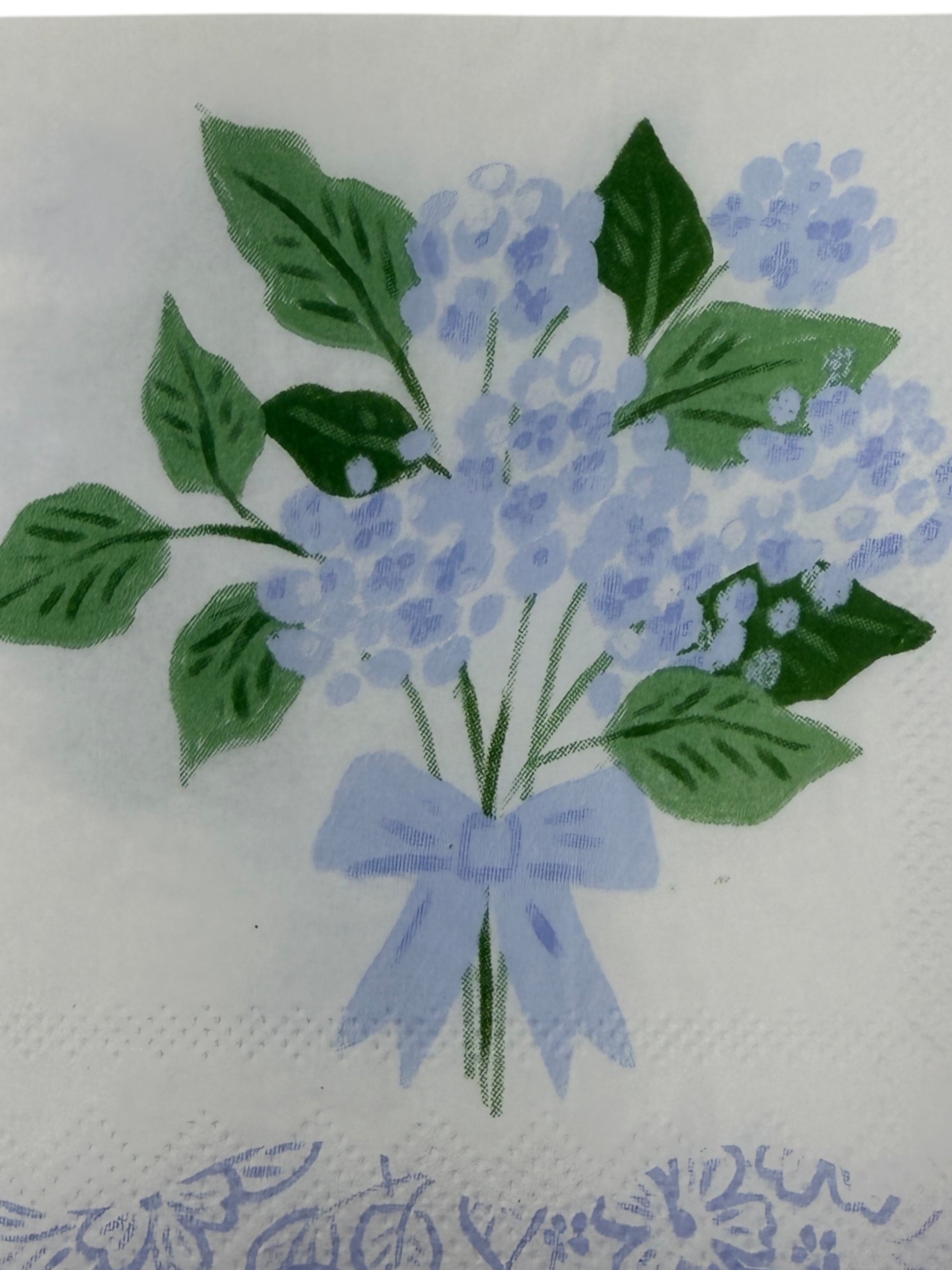 Blue hydrangea scallop edge cocktail napkin with light blue flowers, leafy greens, and floral border