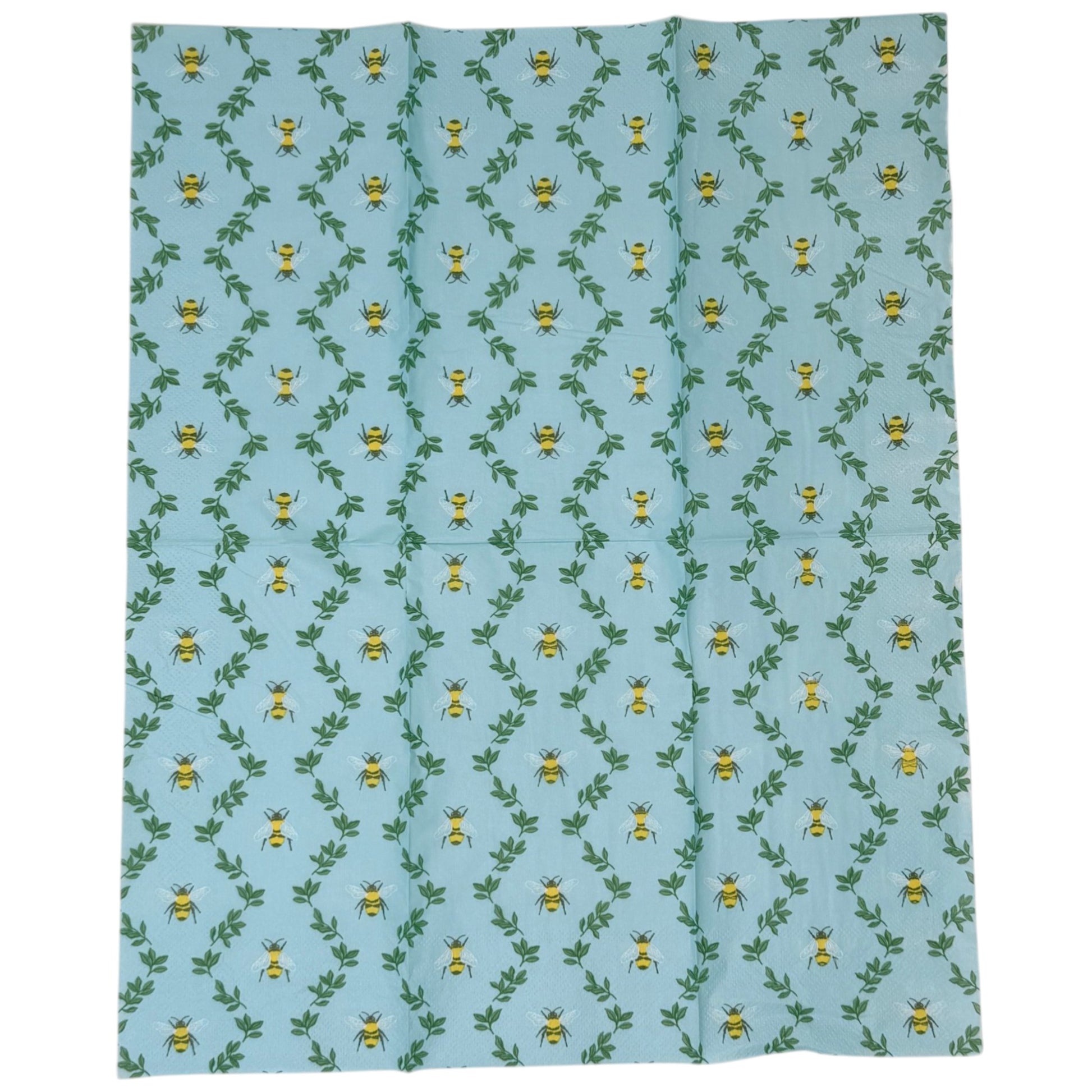 Two guest-size decoupage paper napkins featuring an all-over print of plump yellow and black bumblebees with white wings scattered among delicate green leaf sprigs on a soft sky blue background with a subtle honeycomb texture, photographed on a black surface.