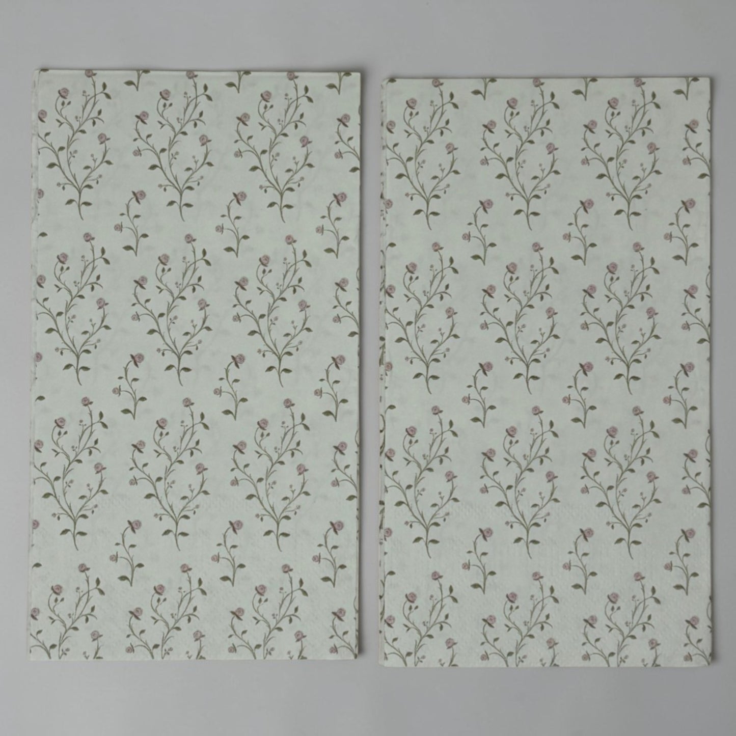 Guest size decoupage napkins featuring delicate trailing rose vine cascades with tiny blush pink rosebuds and soft olive gold leaves on a warm creamy ivory background set of 2