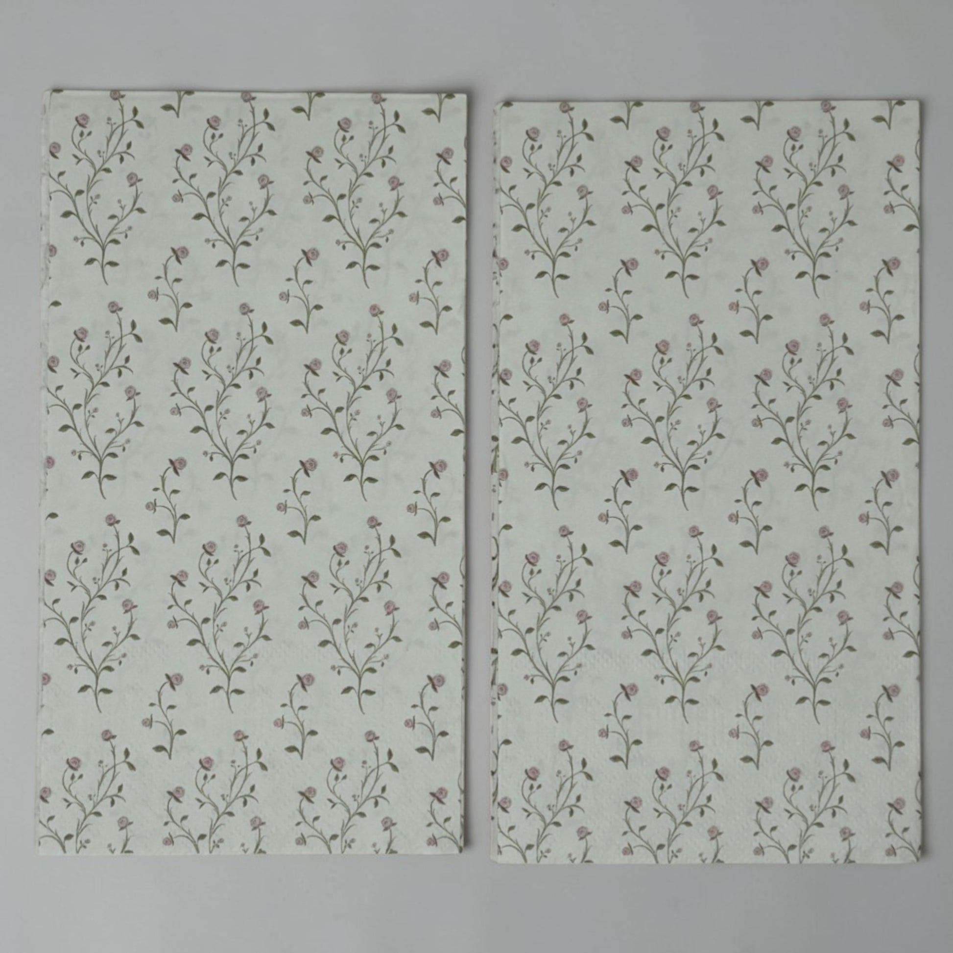 Guest size decoupage napkins featuring delicate trailing rose vine cascades with tiny blush pink rosebuds and soft olive gold leaves on a warm creamy ivory background set of 2
