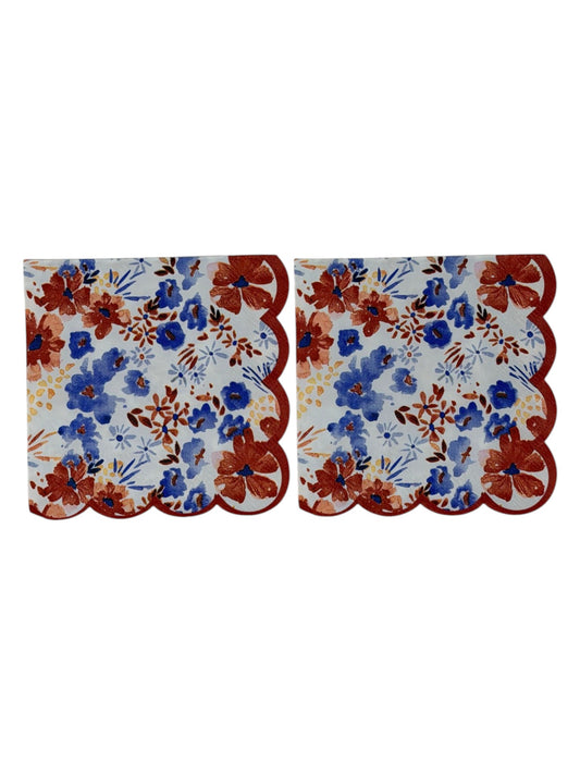 Cocktail-size decoupage paper napkin with a distinctive red scalloped edge featuring a watercolor floral print of cornflower blue blooms, deep rust red flowers, soft blush pink petals, and golden accents on a crisp white background, photographed on a white surface.