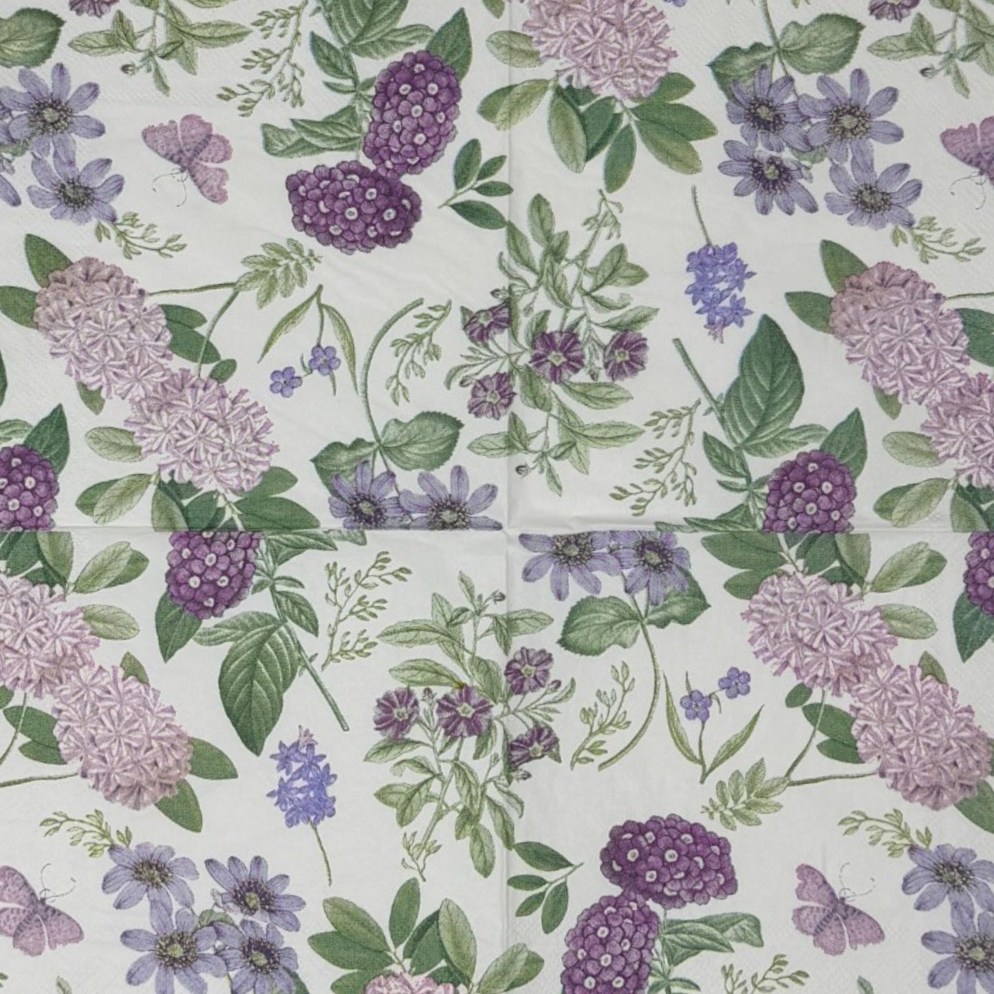 Luncheon-size decoupage paper napkin featuring a vintage botanical illustration print of lavender and purple lilac clusters, periwinkle blue anemones, mauve wildflowers, tiny purple butterflies, and green leaves on a white background with gold foil border stripes, photographed against a white wall.