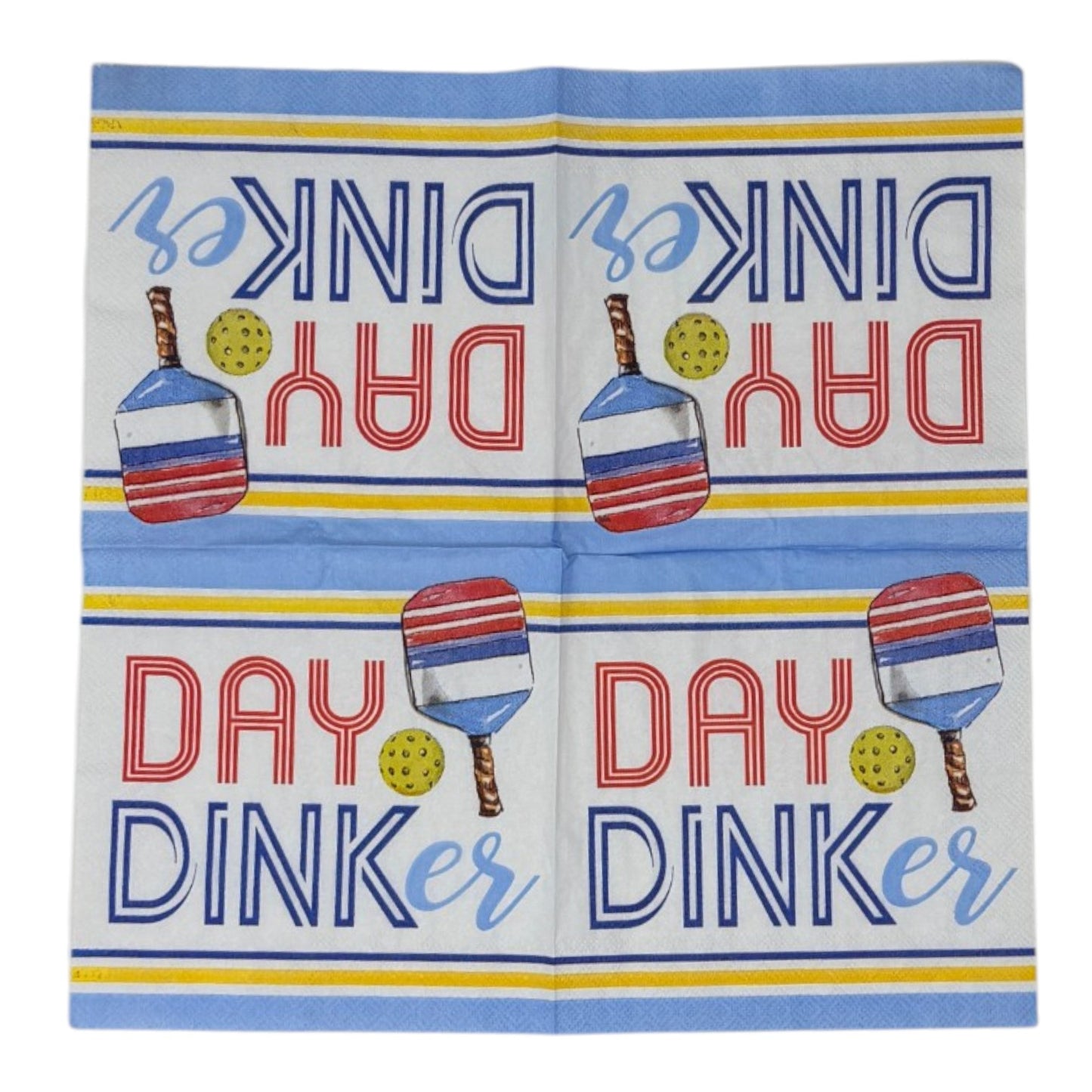 Two cocktail-size decoupage paper napkins featuring a bold graphic design with the phrase DAY DINKer in red and navy lettering alongside a red white and blue pickleball paddle and yellow ball, framed by periwinkle blue and yellow stripe borders on a white background, photographed on a white wall