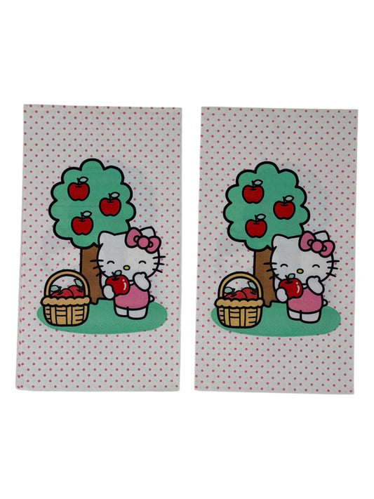 Guest-size decoupage paper napkin featuring a centered illustration of Hello Kitty in a pink bow standing beside a green apple tree with red apples and a wicker basket of apples on a white polka dot background, photographed on a white surface.