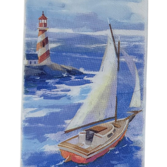 Guest-size decoupage paper napkin featuring a watercolor illustration of a classic wooden sailboat with white sails on deep blue choppy waves with a red and white striped lighthouse on rocky shores in the misty background, photographed on a white surface.