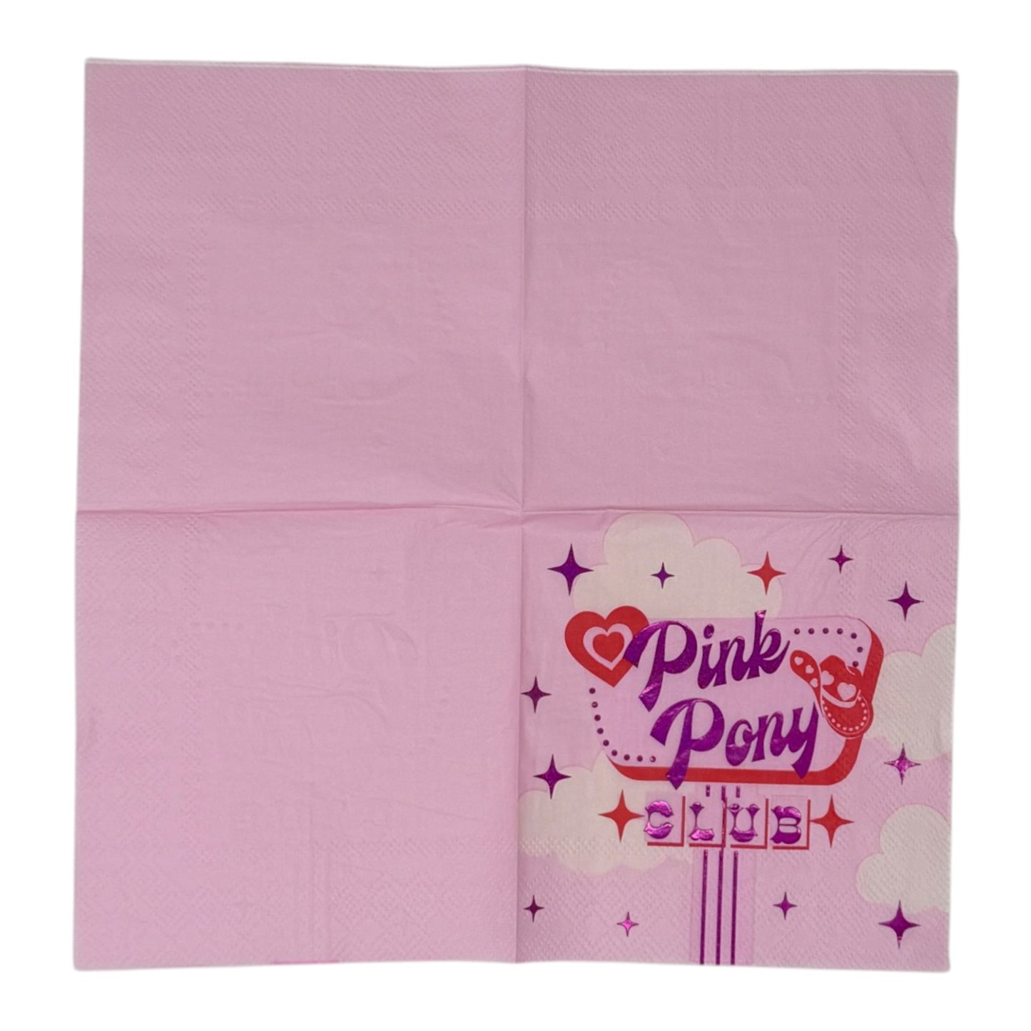 Cocktail-size decoupage paper napkin featuring a retro diner sign graphic with Pink Pony Club in shimmering foil purple lettering on a red marquee frame with a red heart, cowboy boot accent, sparkling four-point stars, and fluffy white clouds on a soft bubblegum pink background.