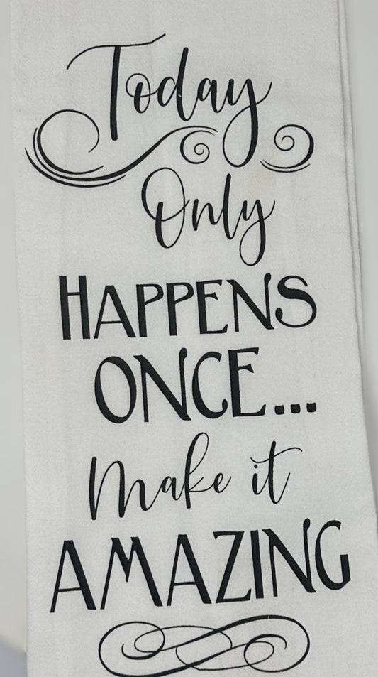 A white flour sack towel with black text textual design saying 'Only Happens Once... Make it Amazing'.