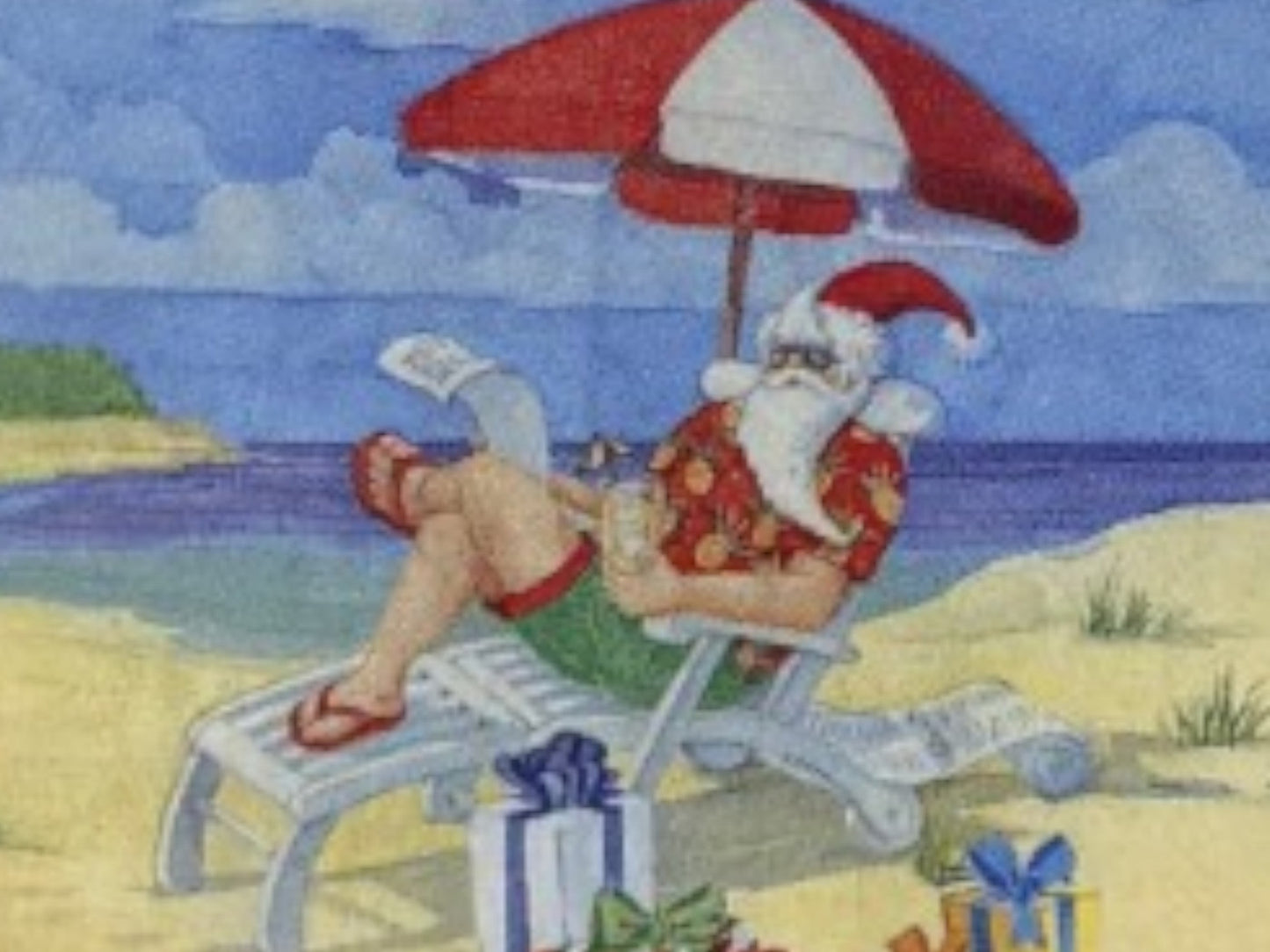 Santa Claus lounging on a beach chair under an umbrella with presents nearby.