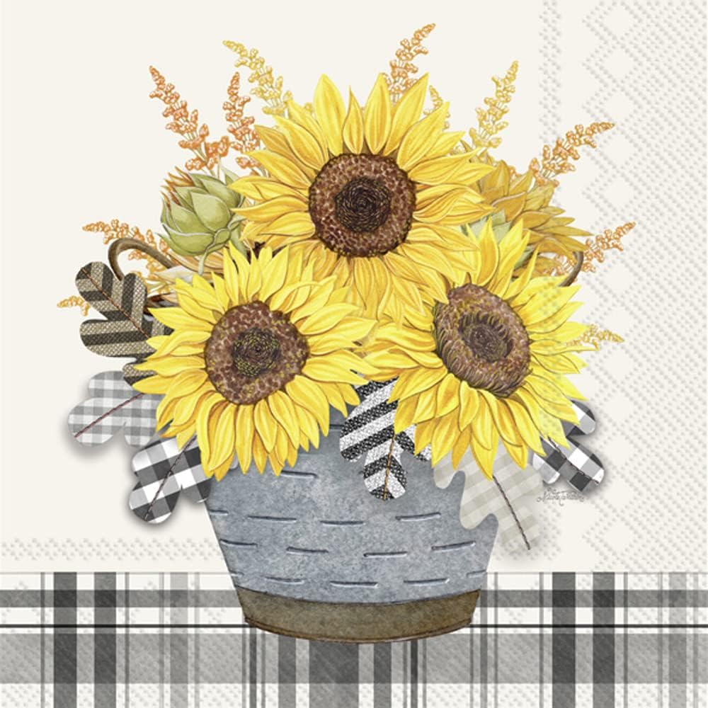 Cocktail-size decoupage paper napkin featuring three golden yellow sunflowers with deep brown centers in a weathered galvanized metal bucket with orange wildflower sprigs and black and white gingham and plaid leaf accents on a soft cream background with a black and white plaid border stripe.