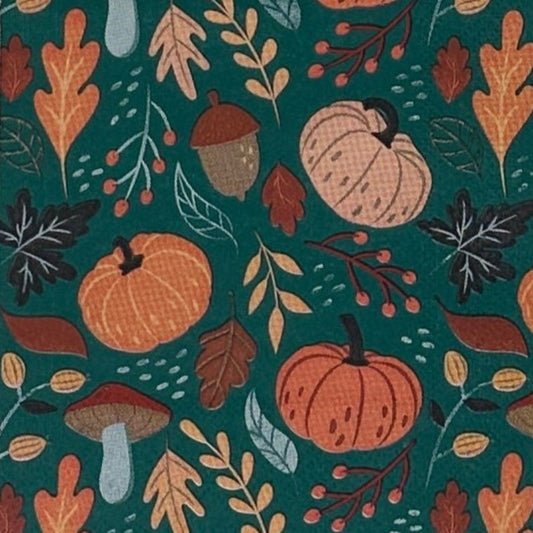 paper napkin with orange pumpkins and brown fall leaves and mushrooms on a green background