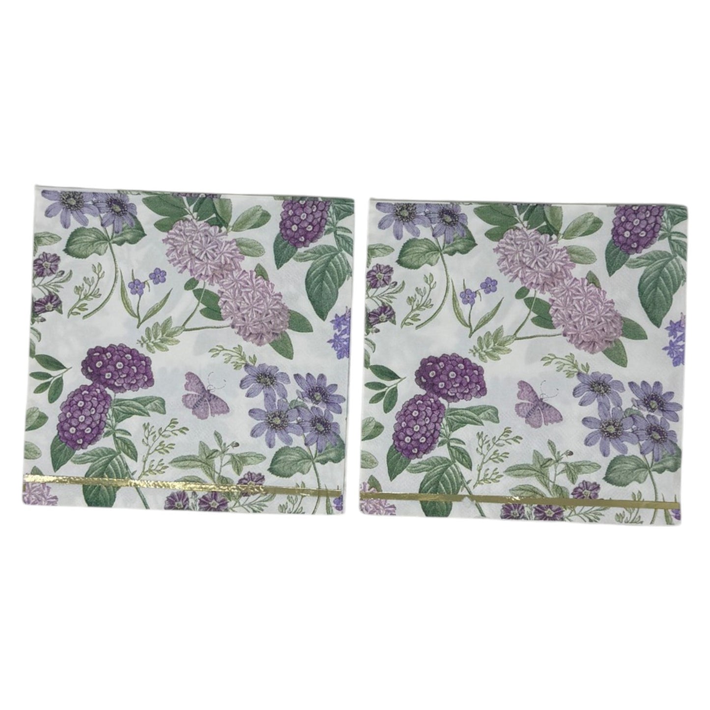 Luncheon-size decoupage paper napkin featuring a vintage botanical illustration print of lavender and purple lilac clusters, periwinkle blue anemones, mauve wildflowers, tiny purple butterflies, and green leaves on a white background with gold foil border stripes, photographed against a white wall.