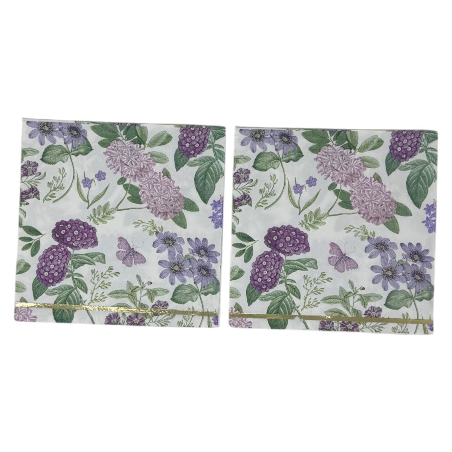 Luncheon-size decoupage paper napkin featuring a vintage botanical illustration print of lavender and purple lilac clusters, periwinkle blue anemones, mauve wildflowers, tiny purple butterflies, and green leaves on a white background with gold foil border stripes, photographed against a white wall.