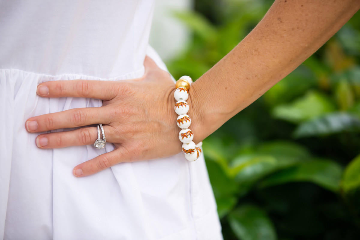 Close-up of a hand wearing a bracelet with a blurred green background