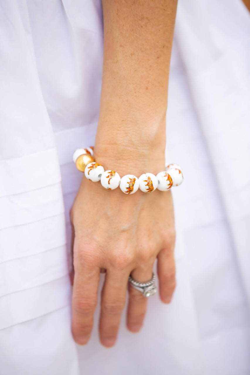 Hand wearing a beaded bracelet on a white background