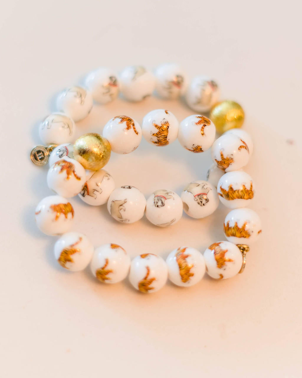 Bracelet with white and gold beads on a light background