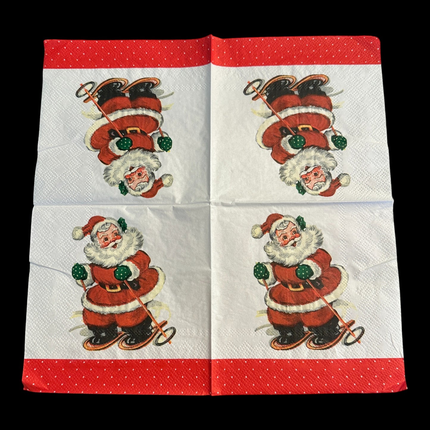 Unfolded Close-up of a cocktail napkin featuring a retro Santa Claus skiing with green mittens and a red suit, set against a white background with a red polka dot  border.