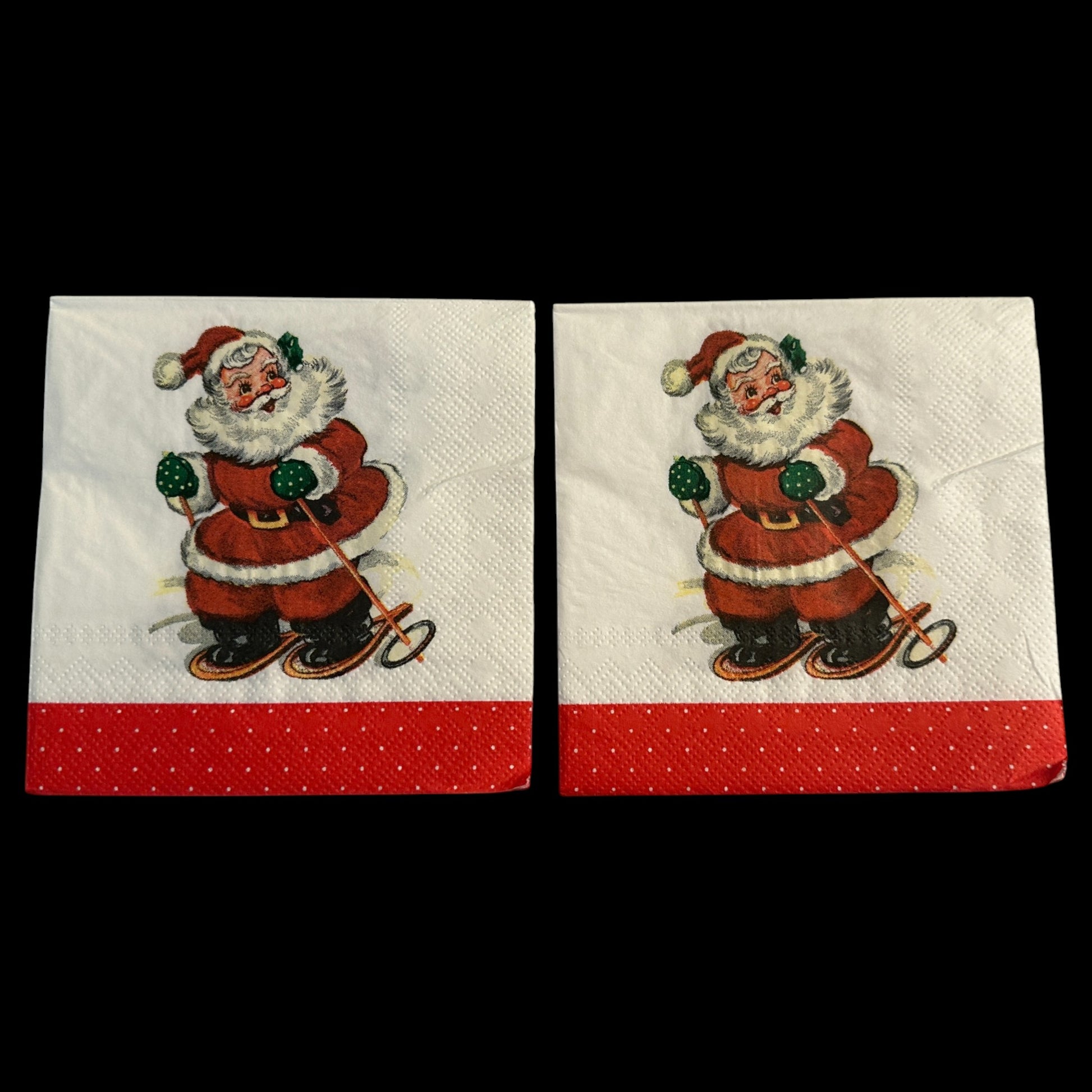 Two Close-ups of cocktail napkins featuring a retro Santa Claus skiing with green mittens and a red suit, set against a white background with a red polka-dot border.