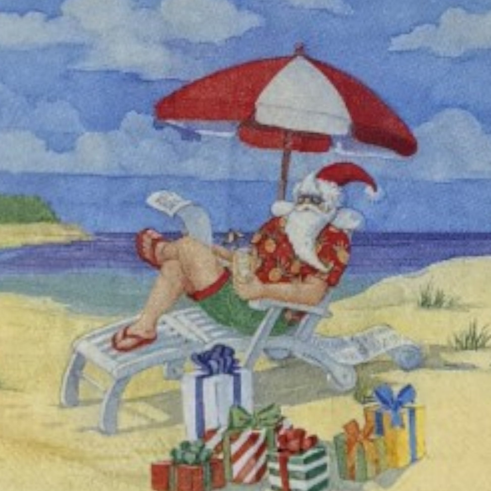 Cocktail-size decoupage paper napkin featuring an illustrated scene of Santa Claus relaxing in a beach lounge chair under a red and white striped umbrella wearing a Hawaiian shirt and flip flops with colorful wrapped gifts in the sand and a bright blue ocean in the background.